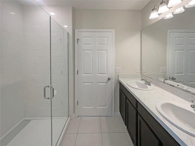 full bath with double vanity, tile patterned flooring, a shower stall, and a sink