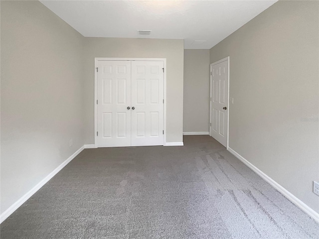 unfurnished bedroom featuring a closet, carpet, visible vents, and baseboards