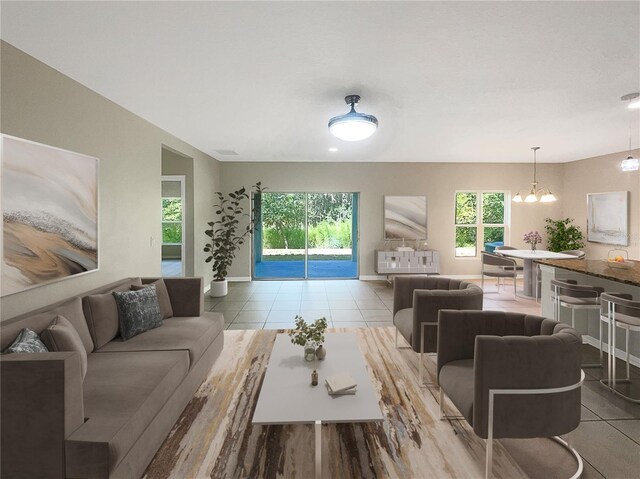 living room with a healthy amount of sunlight, an inviting chandelier, and light tile patterned floors