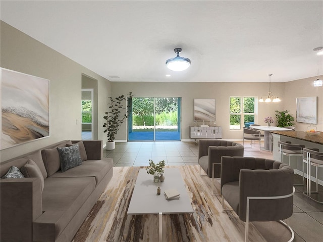 living room with a notable chandelier, baseboards, and tile patterned floors