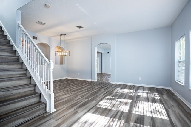 spare room featuring a chandelier and hardwood / wood-style floors