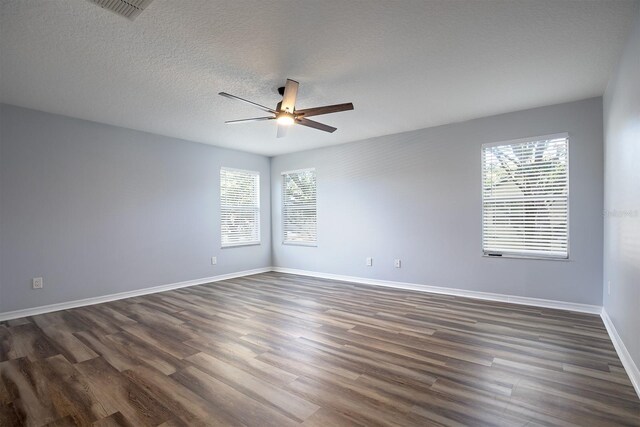 unfurnished room with dark hardwood / wood-style flooring, ceiling fan, and a textured ceiling