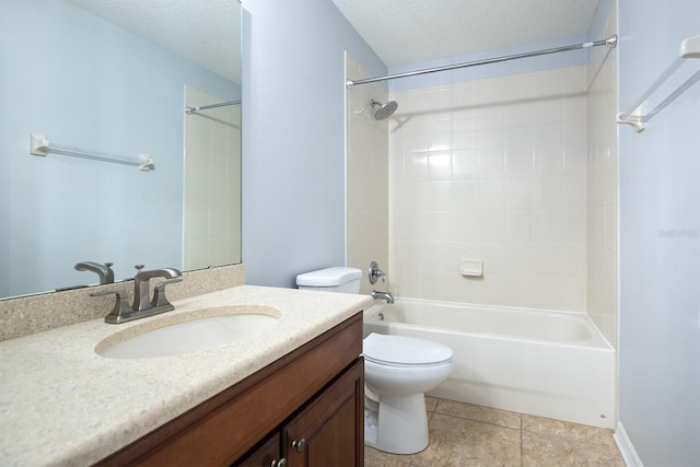 full bathroom with tile patterned floors, toilet, tiled shower / bath combo, vanity, and a textured ceiling