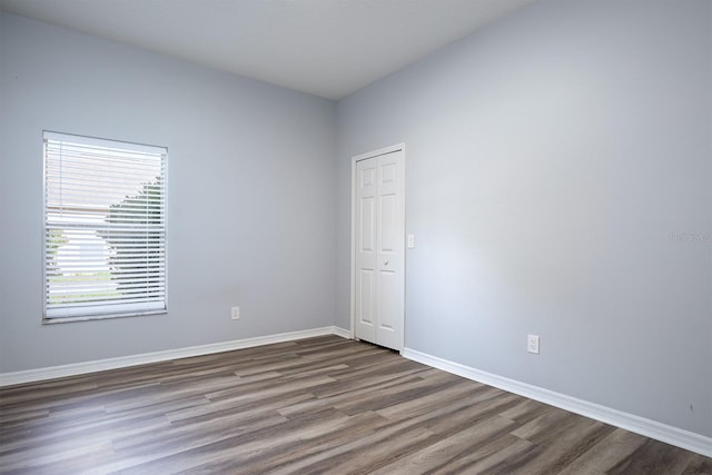 unfurnished room with dark wood-type flooring