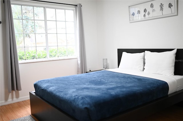 bedroom featuring multiple windows and wood-type flooring