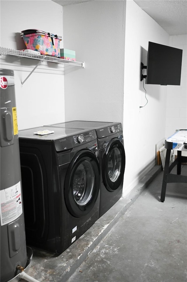 washroom with washer and dryer, electric water heater, and a textured ceiling