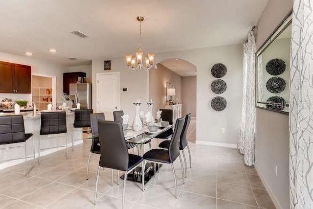 tiled dining room with an inviting chandelier