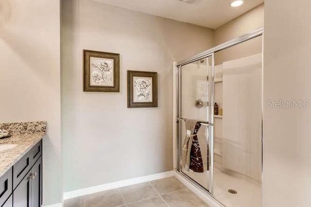 bathroom with vanity, an enclosed shower, and tile patterned floors