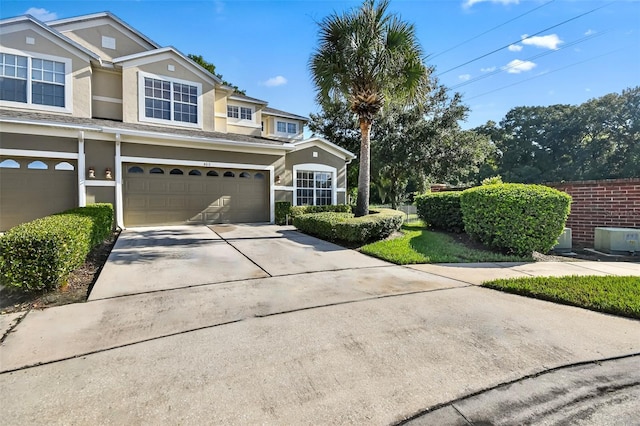 view of front of property featuring concrete driveway, an attached garage, and stucco siding