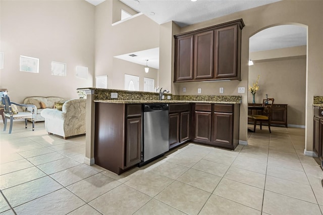 kitchen featuring light stone countertops, dishwasher, dark brown cabinets, and light tile patterned floors