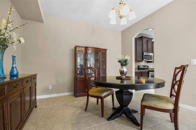 dining space featuring light tile patterned floors, baseboards, arched walkways, and a notable chandelier