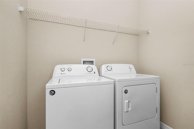 laundry area with laundry area, baseboards, and separate washer and dryer