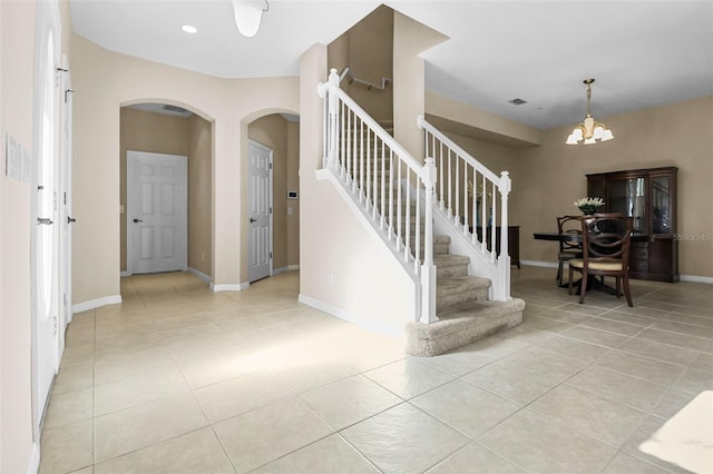 foyer with stairs, baseboards, a notable chandelier, and light tile patterned flooring