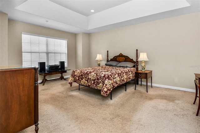 bedroom featuring recessed lighting, baseboards, a tray ceiling, and light colored carpet