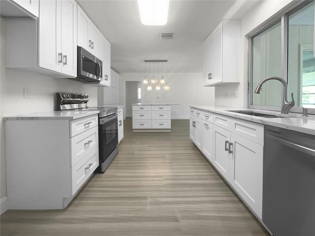 kitchen with stainless steel appliances, a sink, visible vents, white cabinets, and light wood finished floors