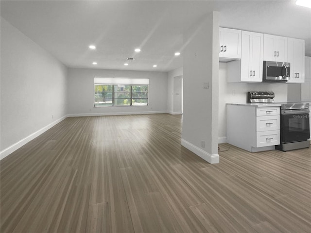 unfurnished living room featuring recessed lighting, baseboards, and wood finished floors