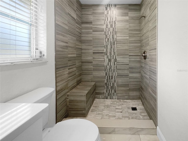 bathroom with tiled shower and toilet