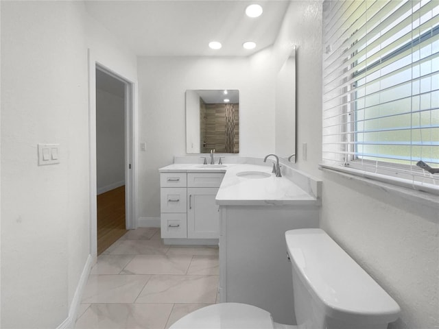 bathroom with recessed lighting, baseboards, vanity, and toilet