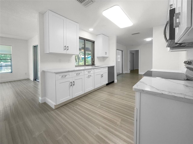 kitchen featuring visible vents, white cabinets, dishwasher, range, and a sink