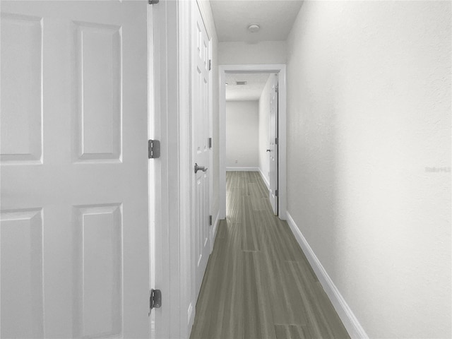 corridor with wood finished floors and baseboards