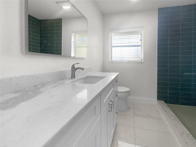 full bath featuring toilet, tiled shower, vanity, and baseboards