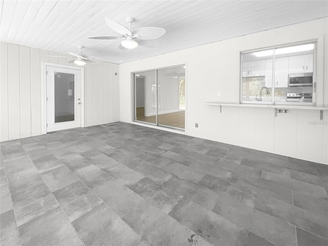 interior space with wood ceiling, ceiling fan, and a sink