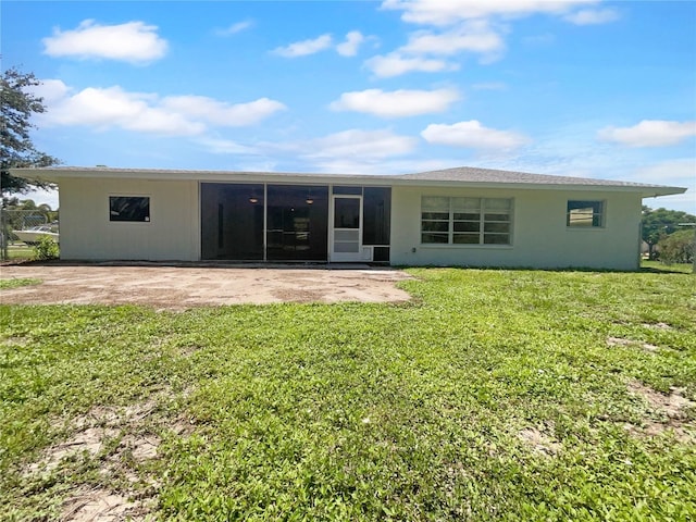 rear view of house with a yard, a patio area, and a sunroom