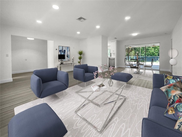 living room featuring baseboards, visible vents, and recessed lighting