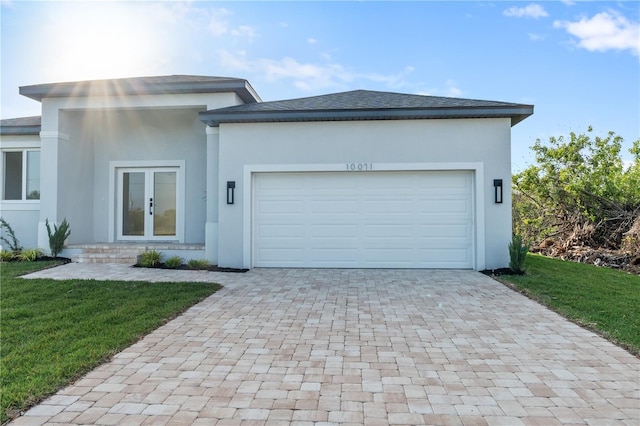 prairie-style house with a garage, a front lawn, and french doors