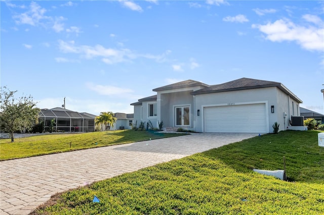 view of front facade with a garage, a front lawn, and central air condition unit