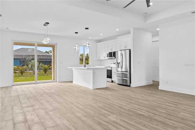 kitchen featuring white cabinetry, a center island, light wood-type flooring, pendant lighting, and stainless steel appliances