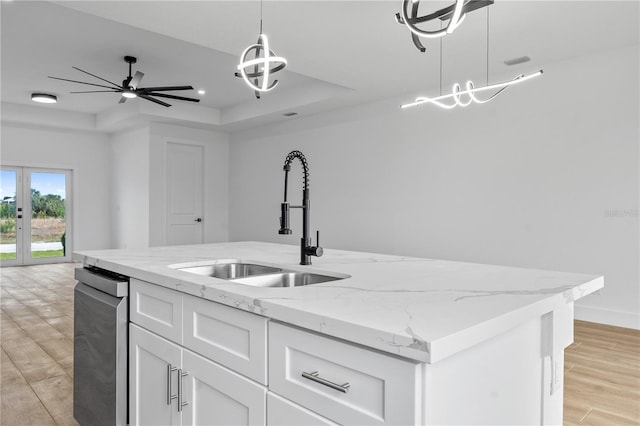 kitchen featuring white cabinetry, hanging light fixtures, a tray ceiling, and sink