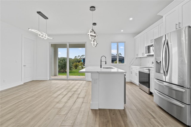 kitchen with white cabinetry, sink, hanging light fixtures, and appliances with stainless steel finishes