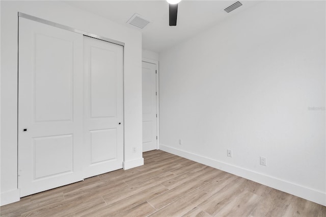 unfurnished bedroom featuring ceiling fan, light hardwood / wood-style floors, and a closet