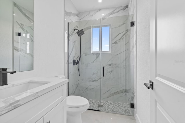 bathroom with vanity, a shower with shower door, and toilet