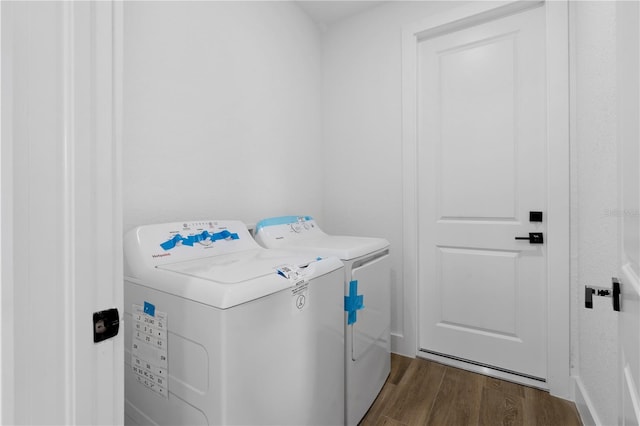 clothes washing area featuring dark hardwood / wood-style flooring and washer and dryer