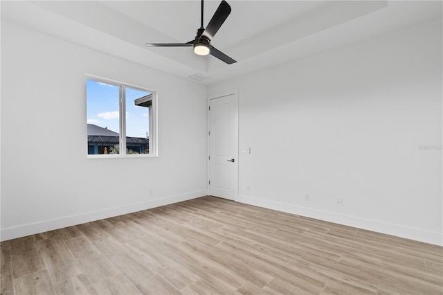 empty room with ceiling fan and light hardwood / wood-style flooring