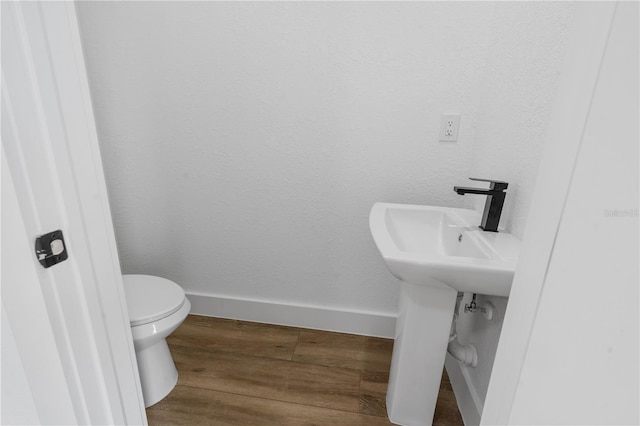 bathroom featuring wood-type flooring and toilet