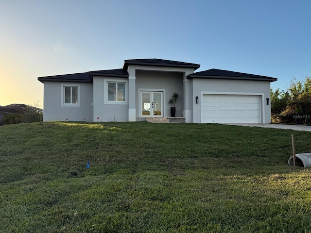 view of front of property with a yard and a garage