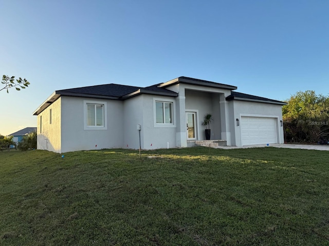 ranch-style house featuring a garage and a lawn