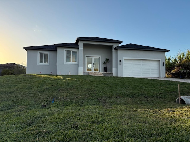 view of front facade featuring a garage and a lawn