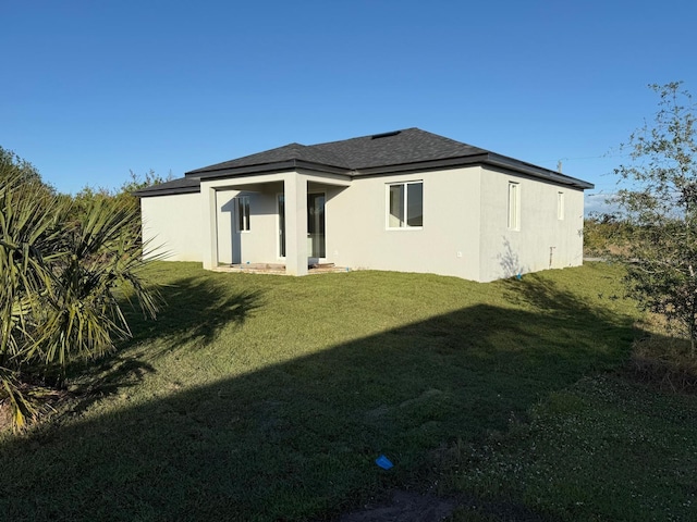 rear view of property featuring a yard