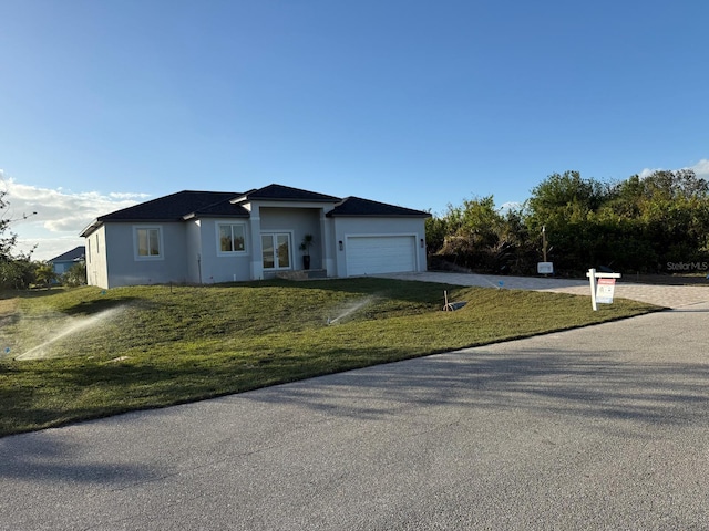 ranch-style house with a garage and a front lawn