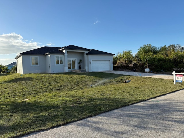 view of front of house with a garage and a front lawn