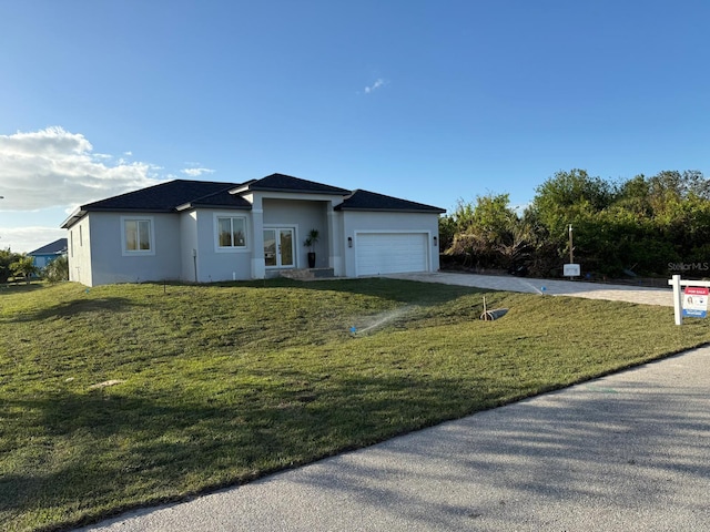 view of front of property with a garage and a front lawn