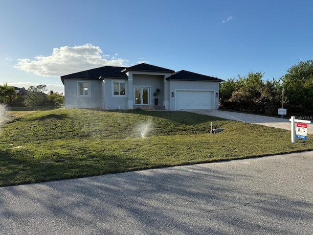 view of front of home with a garage and a front lawn