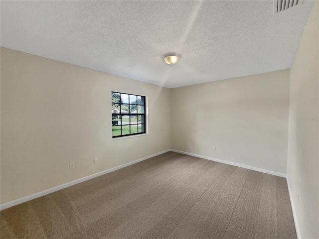 empty room with a textured ceiling and carpet floors