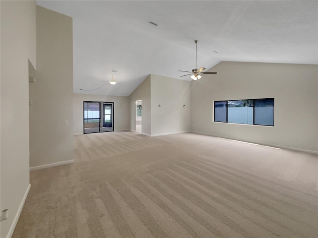 unfurnished living room featuring a ceiling fan, visible vents, baseboards, high vaulted ceiling, and light carpet