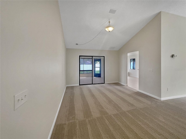 empty room with baseboards, light colored carpet, and high vaulted ceiling