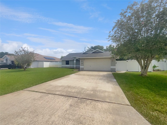 ranch-style house featuring a gate, fence, concrete driveway, a front yard, and a garage